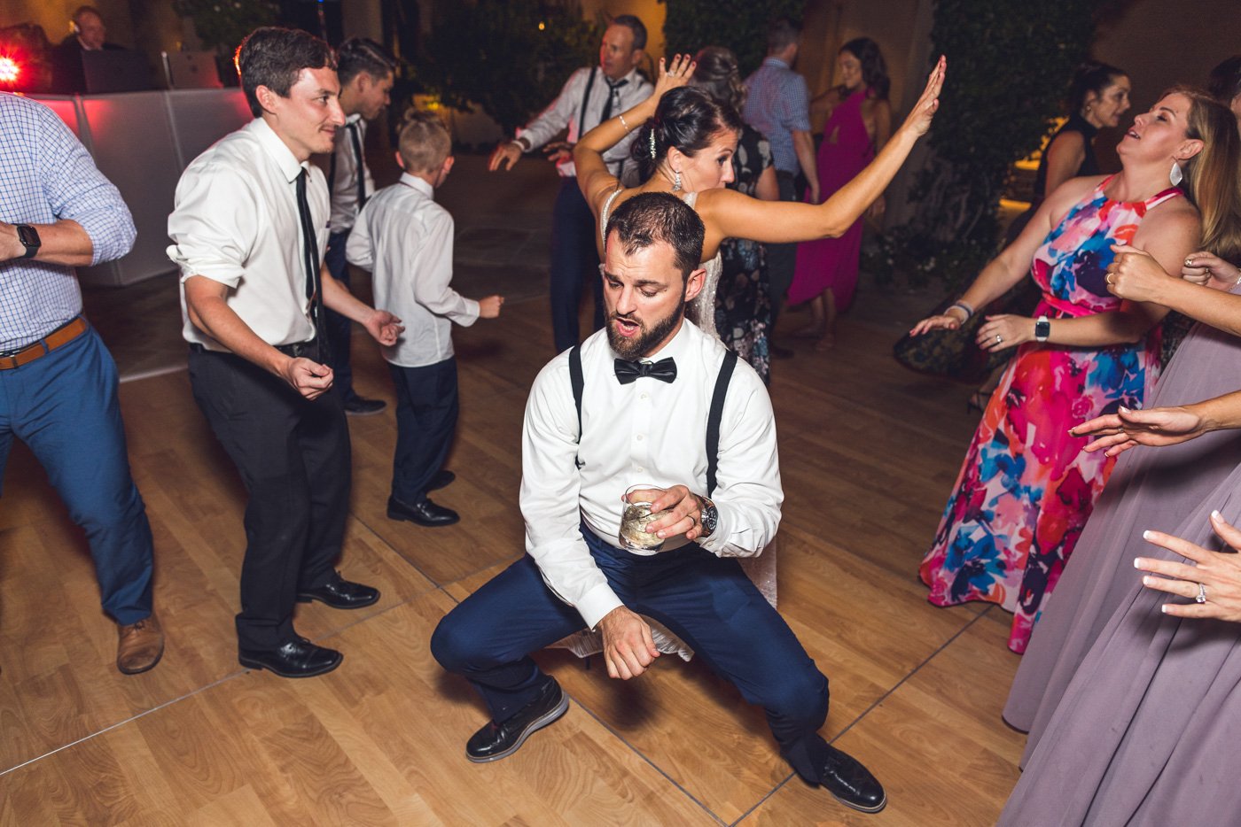 groom dances in front of bride at wedding reception