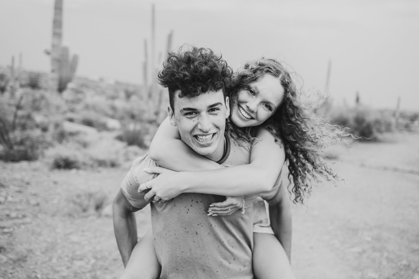 woman getting piggy back ride in desert while both smile