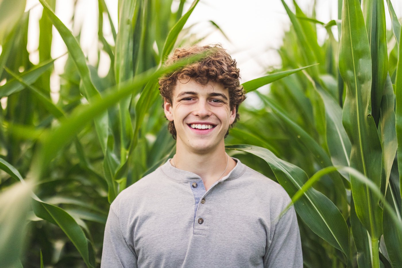 senior smiling in front of corn in minnesota