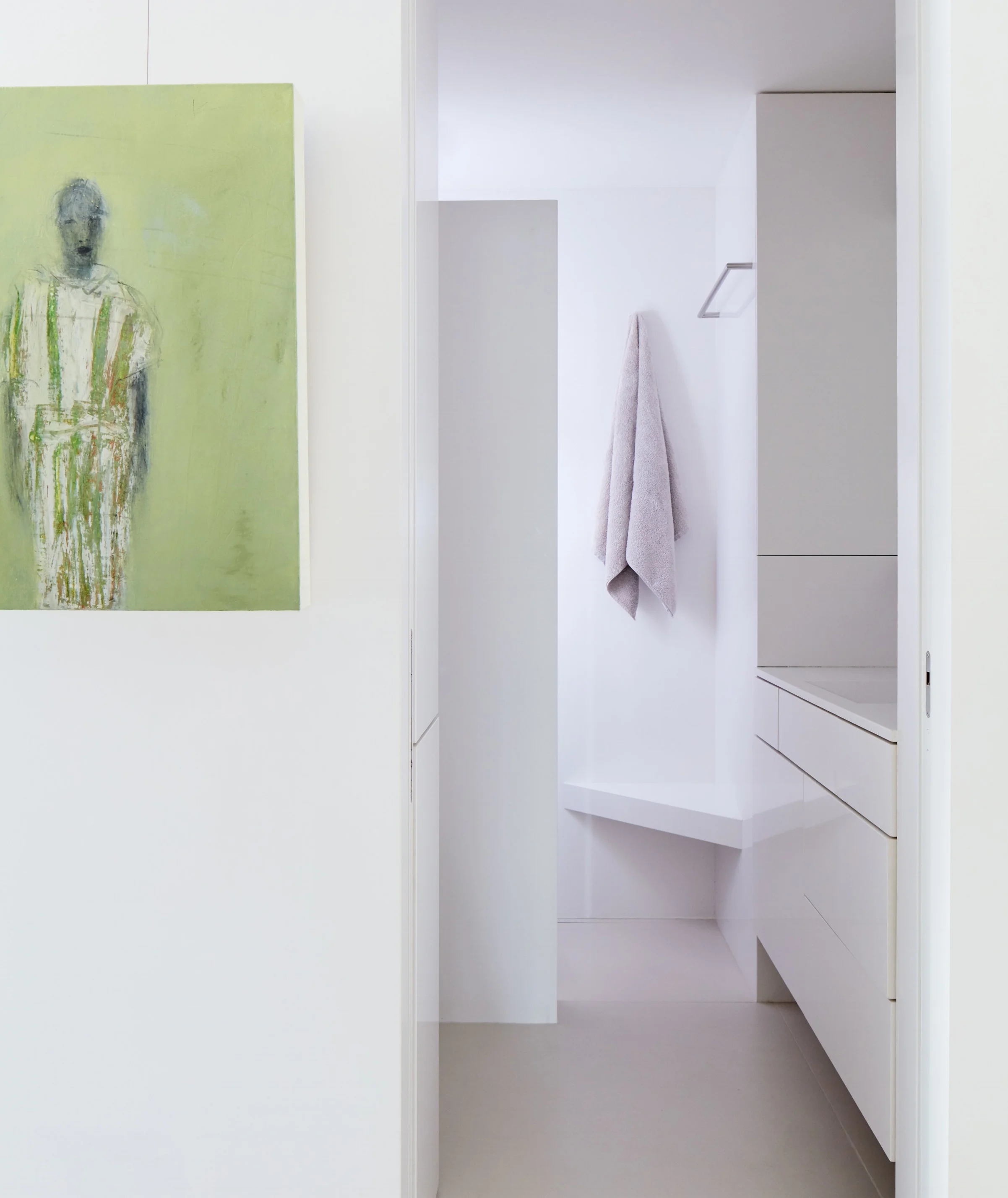 A painting by Marianne Kolb adds a burst of color to the all-white guest bathroom. 