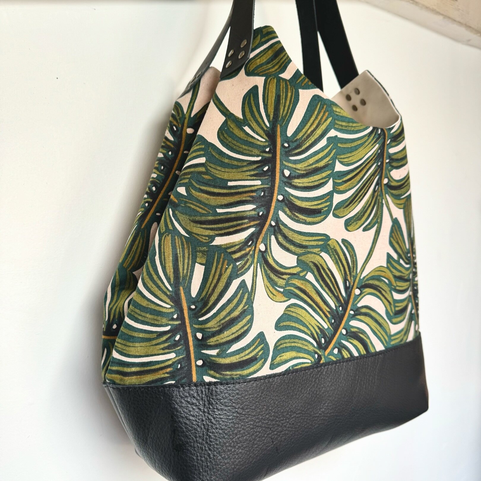 🌿 Our bestselling bag and fabric come together to make magic. The versatile NW Convertible Tote in Monstera! Gorgeous linen canvas, roomy interior pockets, convertible design to quickly expand for more space, brass hardware / closure and lux leather