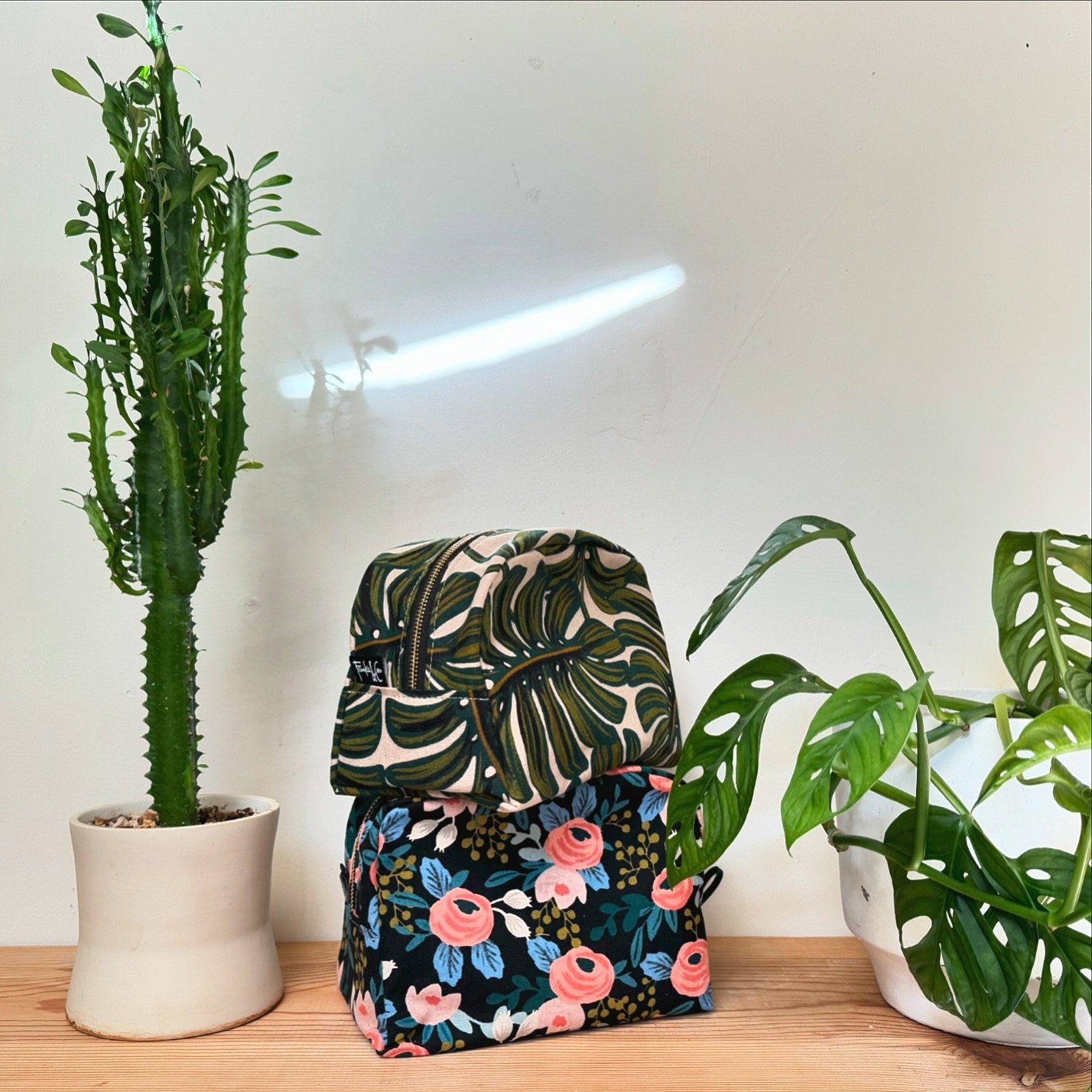 These lovelies are ready for some summer travel! Our West Dopp Kit in Monstera and Dark Rose in perfect for organizing all your toiletries in style. Lined in a wipeable, water resistant nylon. With brass zipper and leather pull. Comes in two sizes! 
