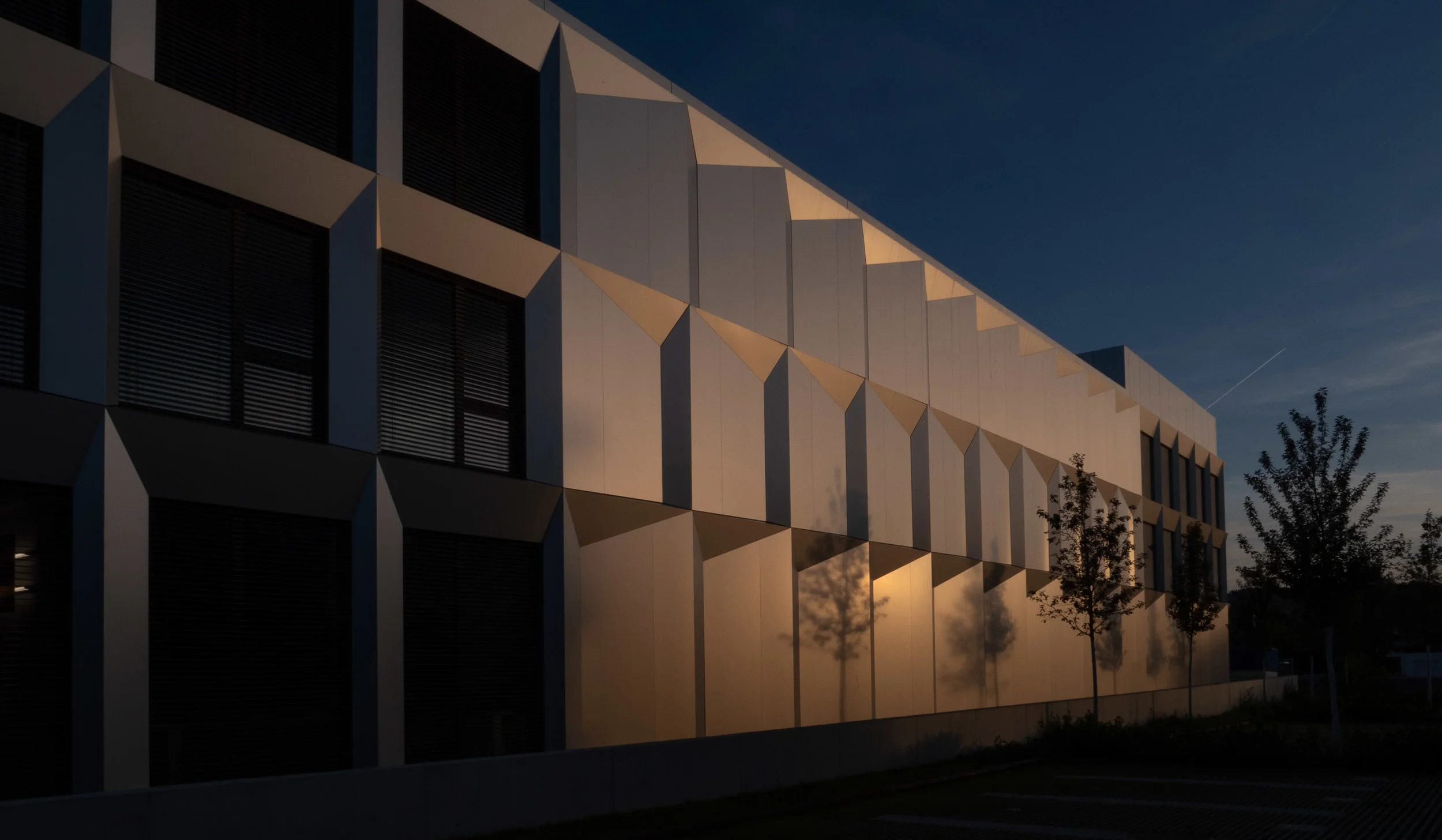 Magisches Licht am Abend. Die letzten Sonnenstrahlen lassen die ALUCOBOND®-Platten in warmen Tönen erstrahlen.