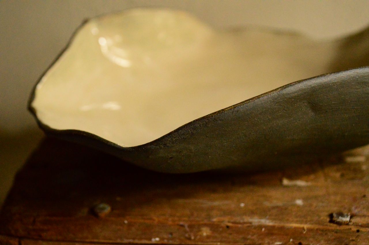 Stoneware bowl, thrown and altered, interior glazed and exterior raw black. 