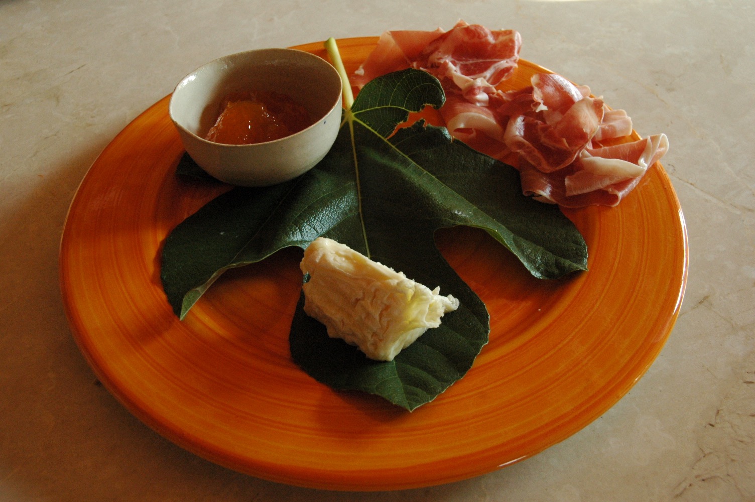 Goat cheese and prosciuttto served on a fig leaf with sweet onion jam 