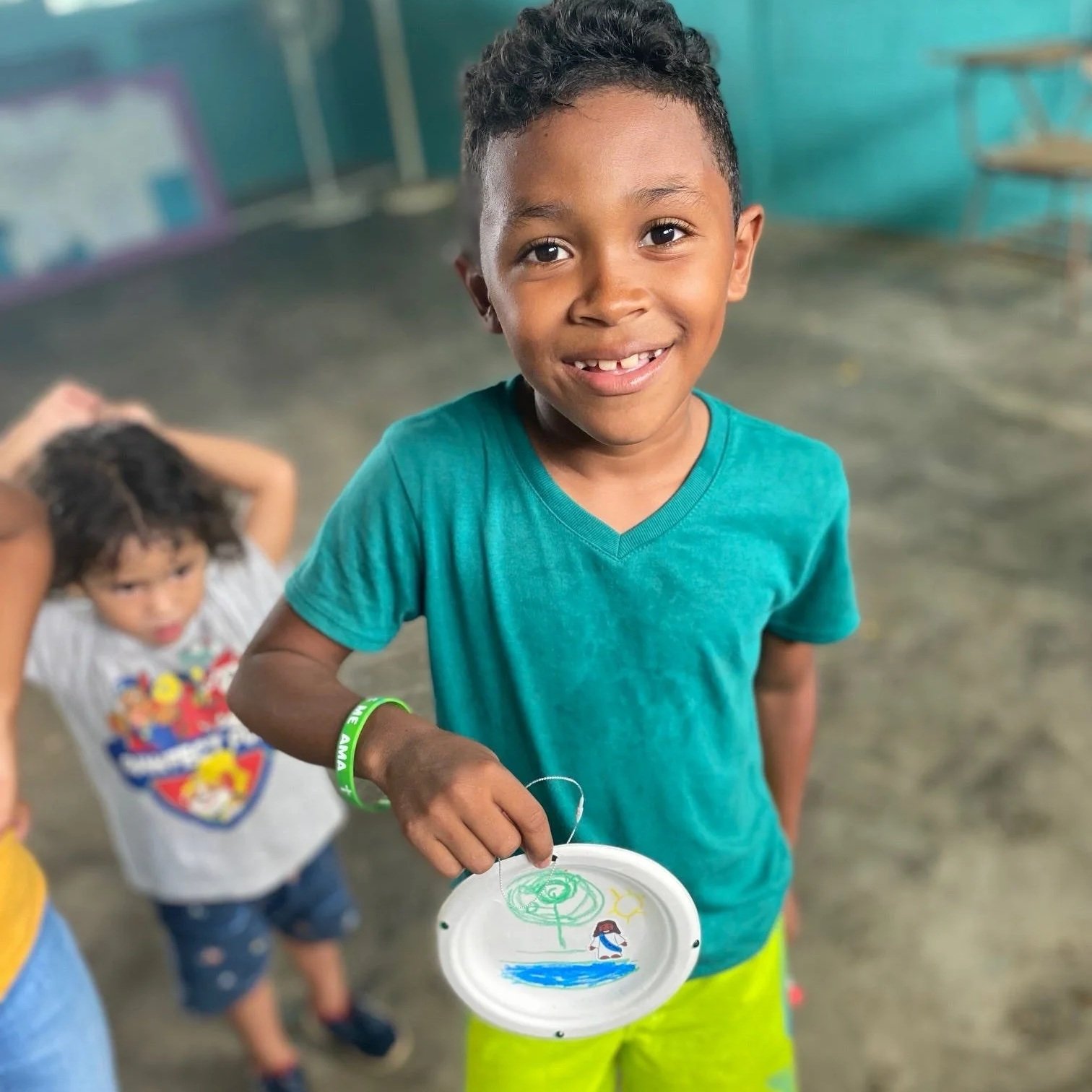 Child proudly displaying his art.