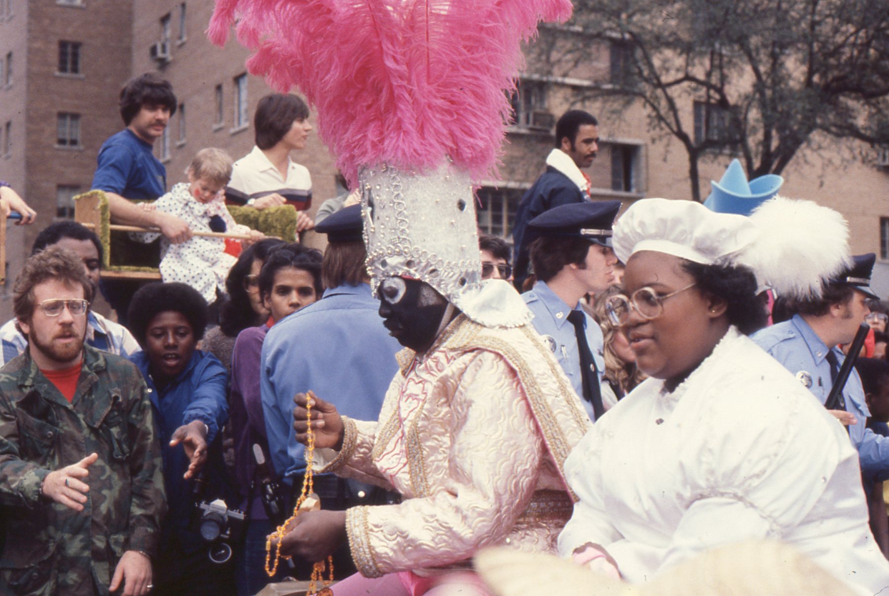 Begging for beads. "Throw me something, Mister!" 