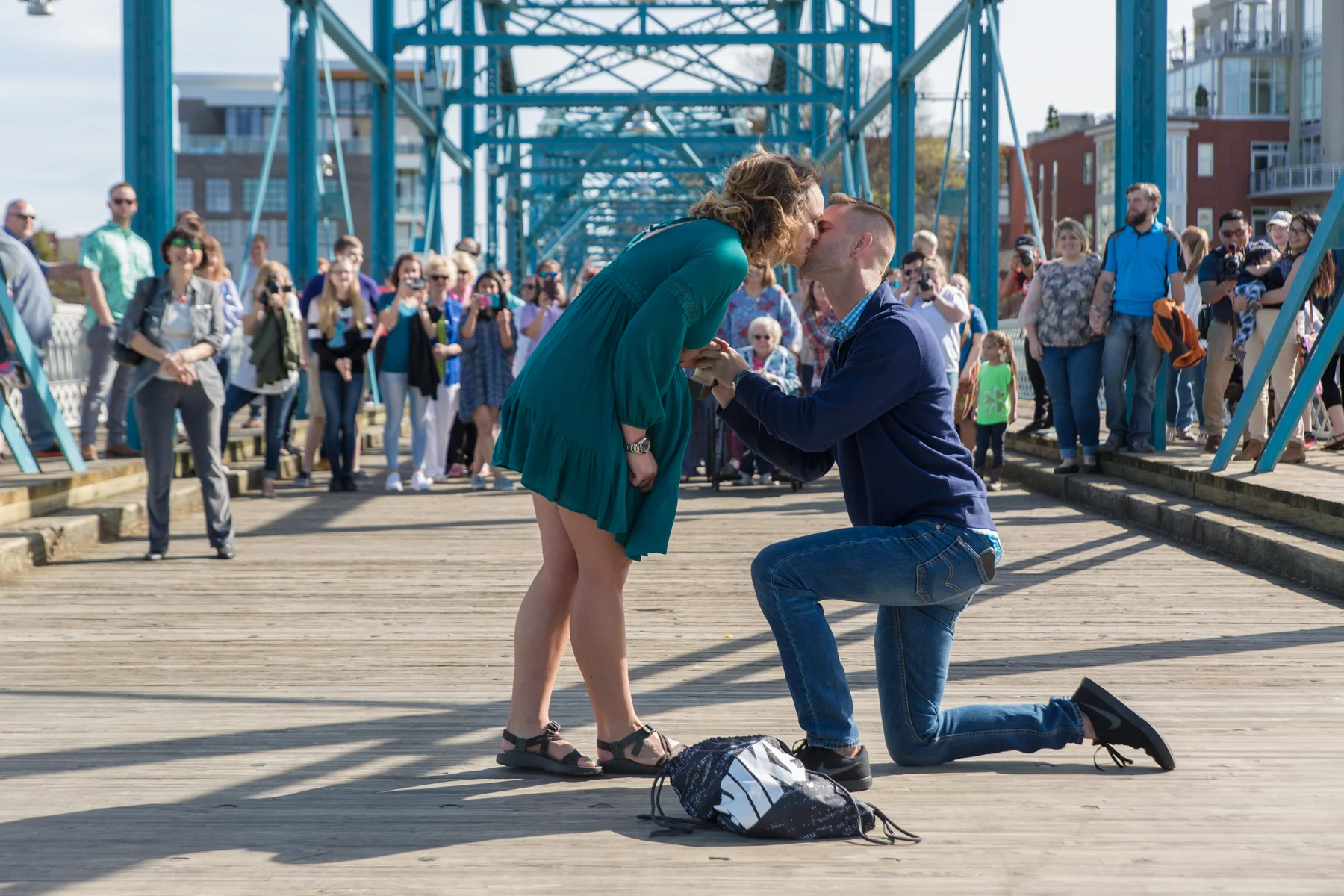 All those people behind them were family members who snuck up as Chase led Sarah to the middle of the bridge.