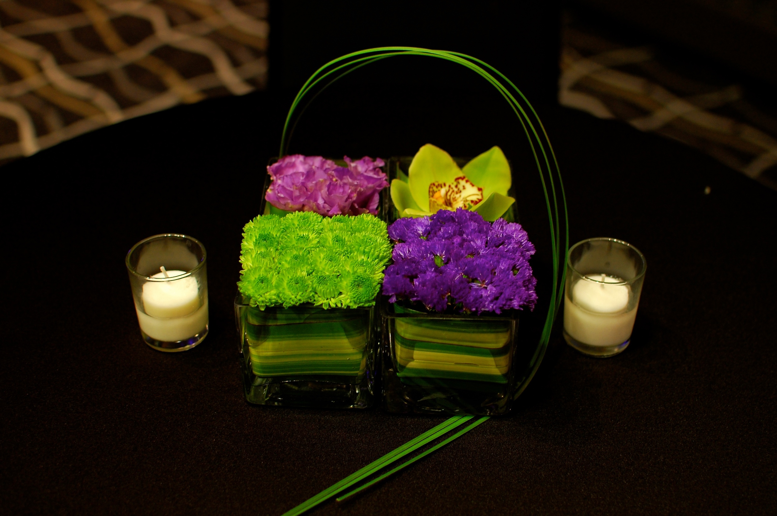 Four vases of different green and purple flowers created an interesting centerpiece tied together with some bear grass.