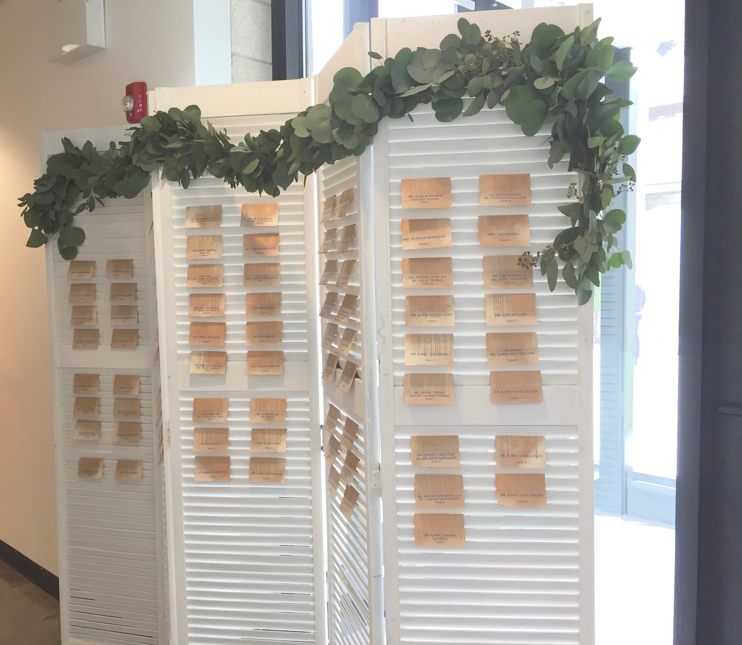 The bride used old pages from a book for her place cards. They fit perfectly into the slats of the screen.