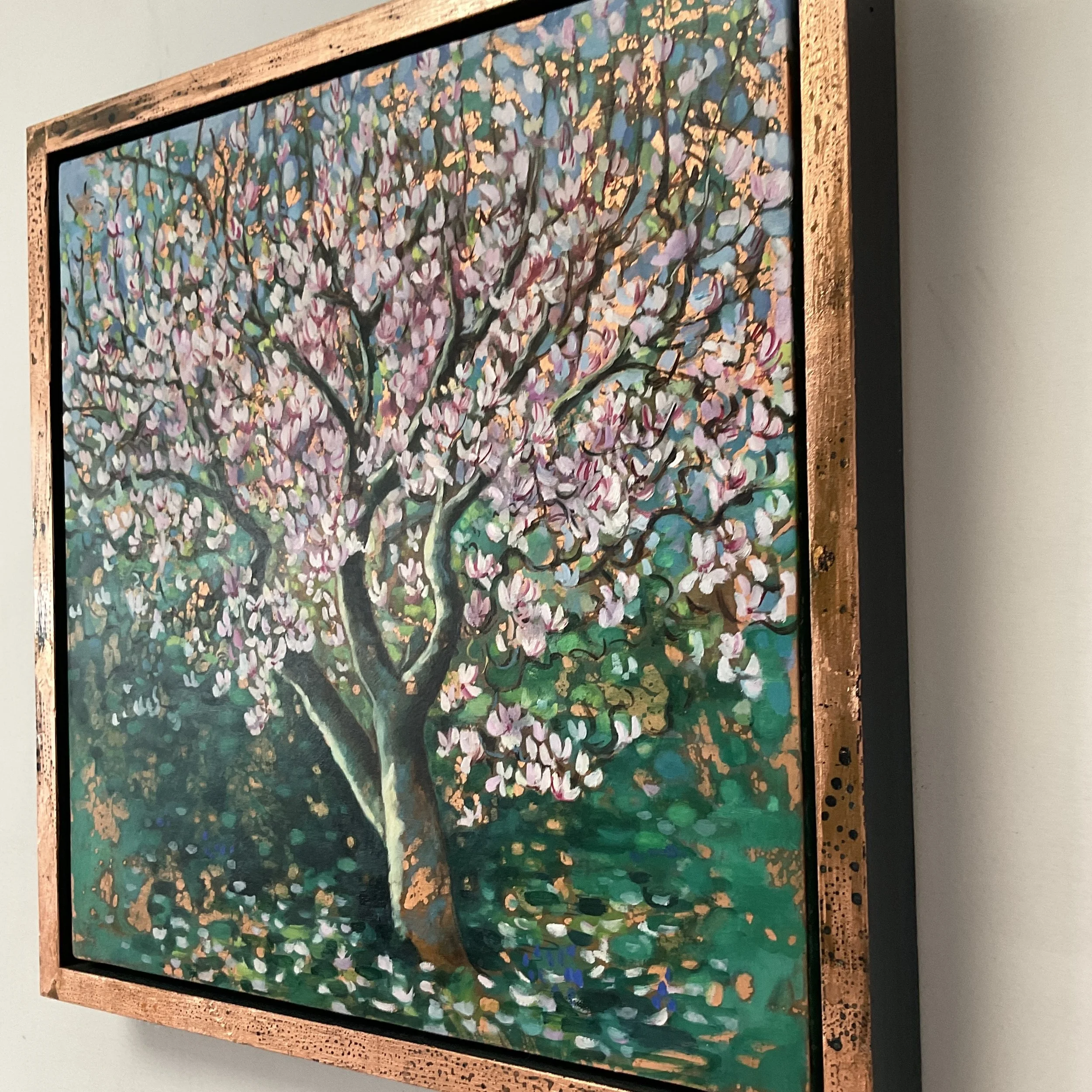 Painting by Alexandra Brown of Magnolia tree with pink flowers with dappled sunshine expressed by shining copper-leaf, framed