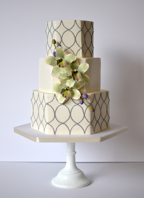 Hexagonal cake with sugar orchids and piped geometric design. Image © Carla Schier