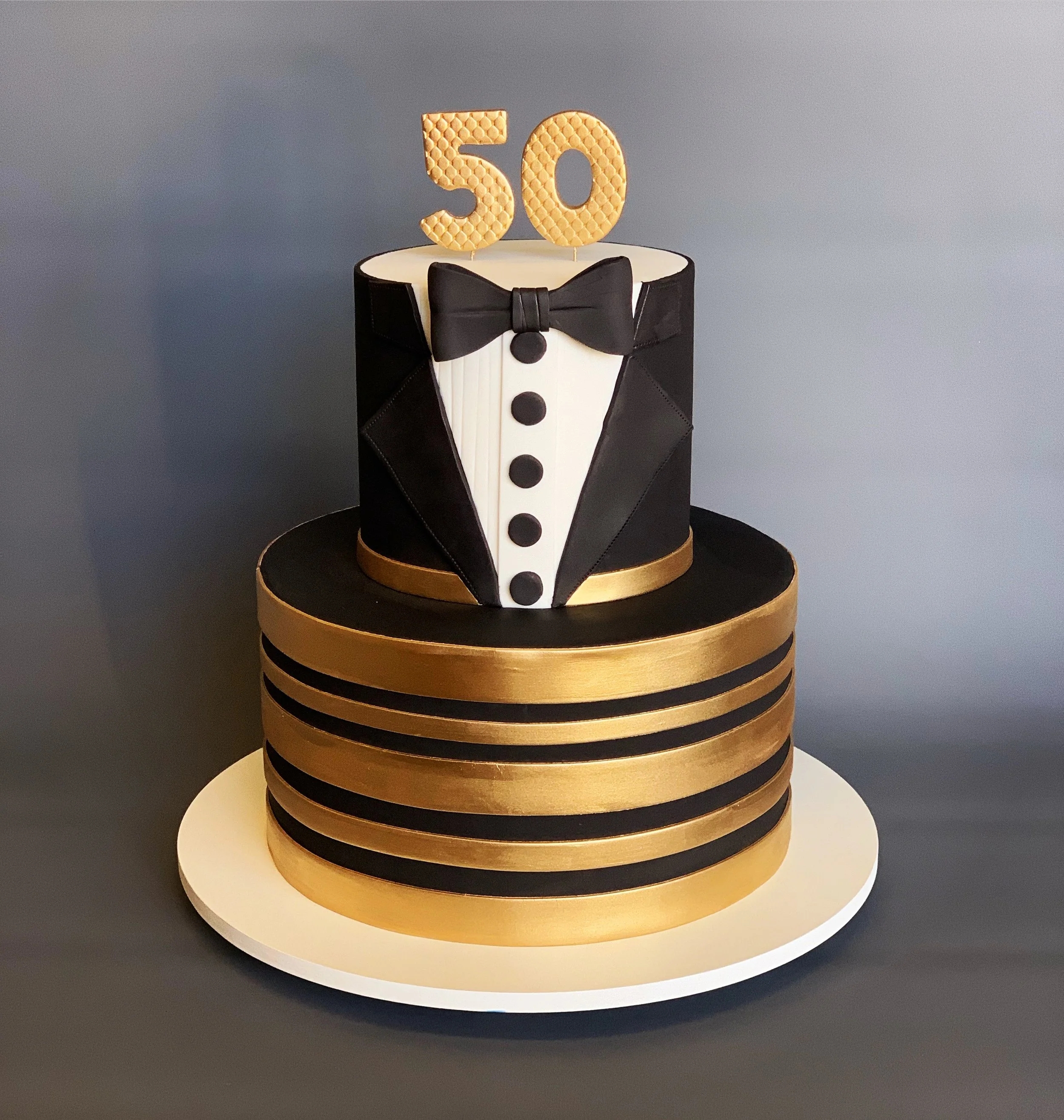 Gold and black tuxedo-themed cake for 50th birthday. Image copyright Carla Schier.
