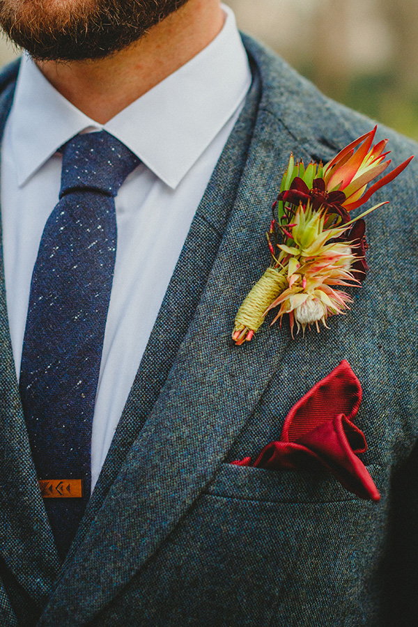 TK's boutonniere included blushing bride protea, chocolate cosmos, and safari sunset for a masculine yet romantic appeal.