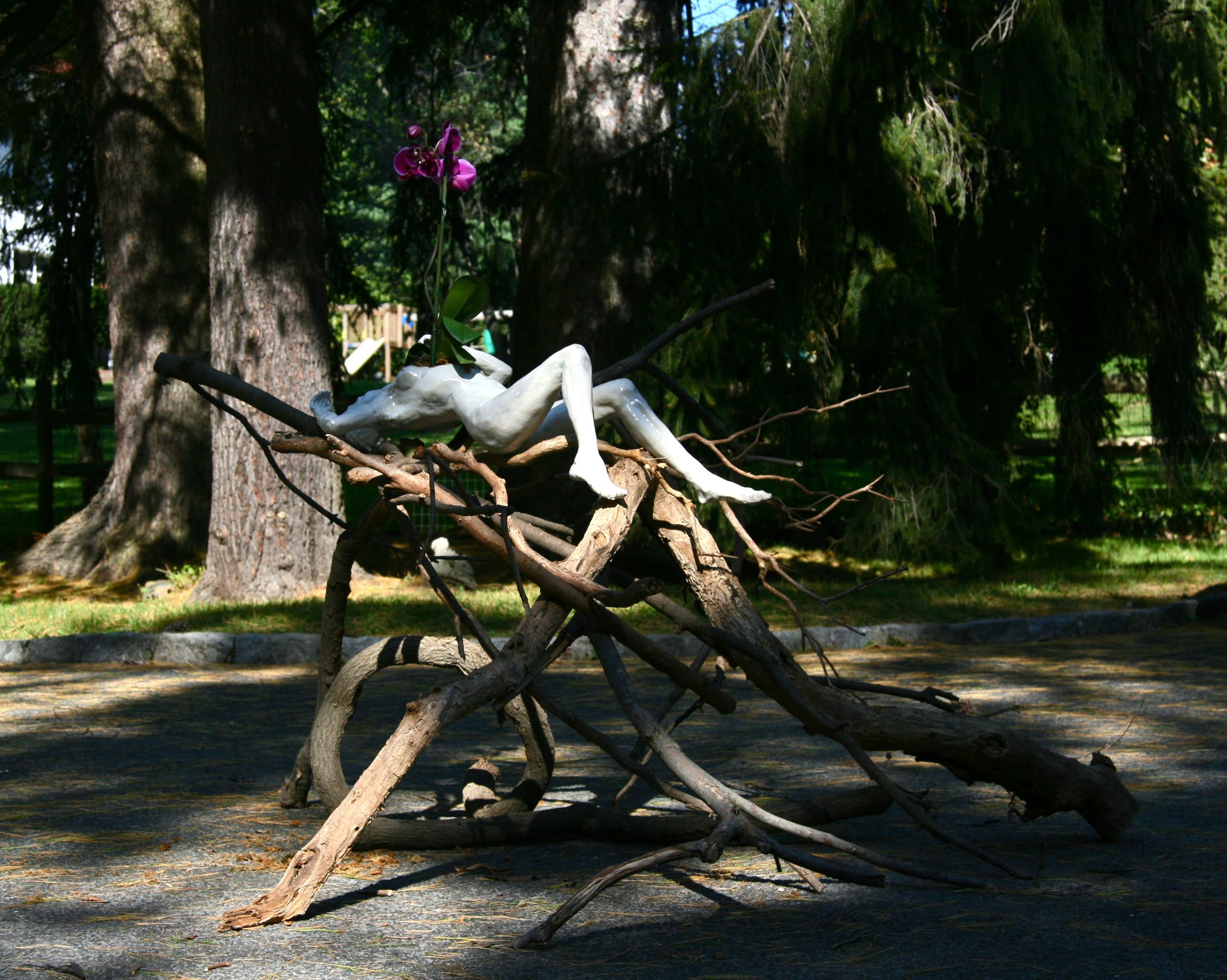   Woman with Orchid, on branches, installation view,  5'x6'x40"H, raku-fired stoneware, branches, orchid 