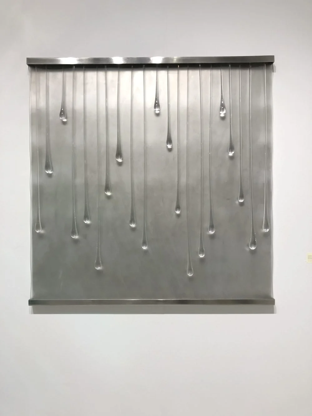  Works by Kathleen Mulcahy, represented by Kim Foster Gallery.  I spoke with Kim and these can be created for you in any size.  Stainless steel back, glass drops, wall mounted. 
