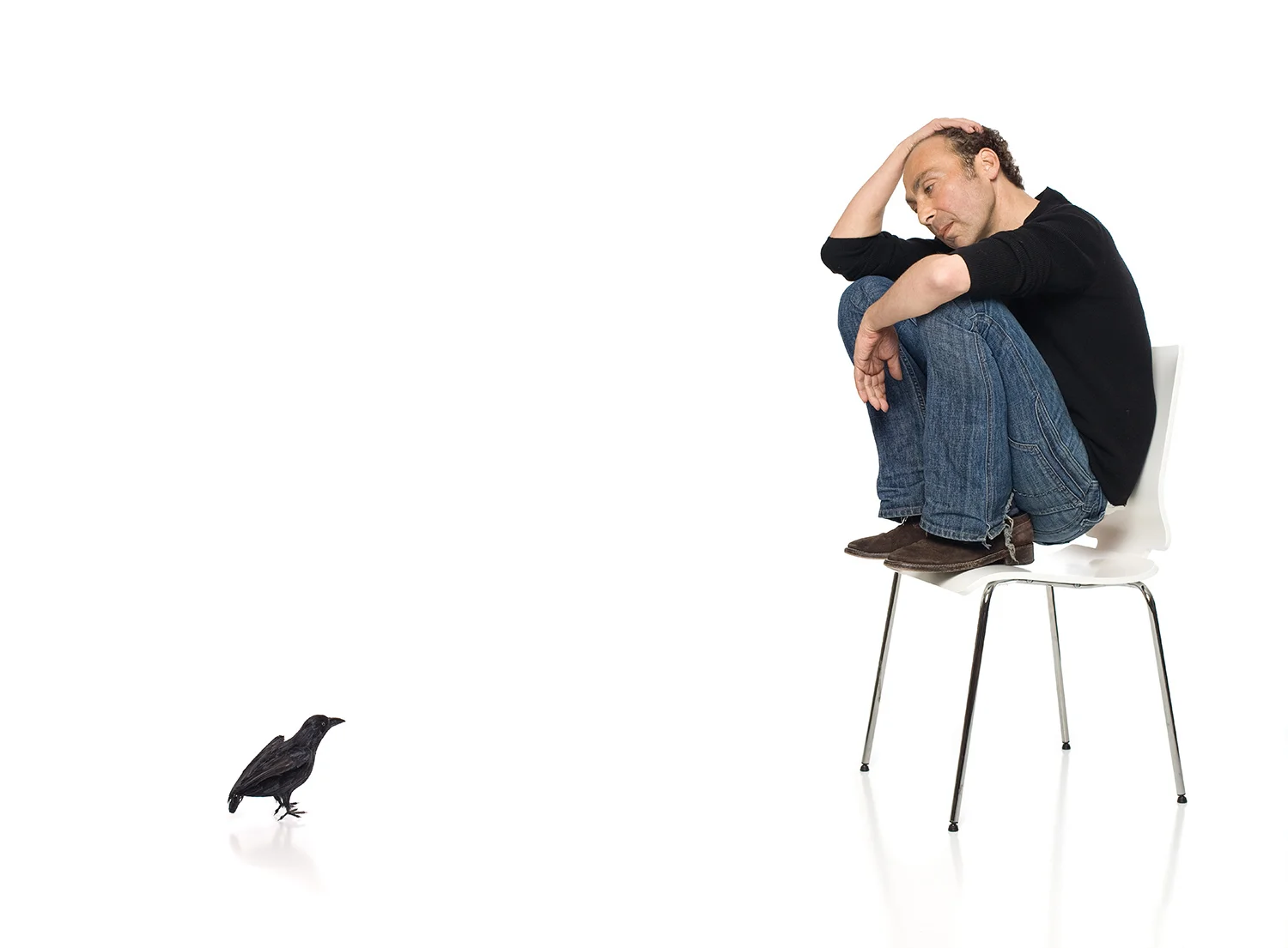  It was that very first meeting when he shared with me that he was diagnosed with Cancer.&nbsp;  The first shot we did together was of Taylor in a stark white setting, curled up in a chair with a black crow on the ground staring up at him. At first g