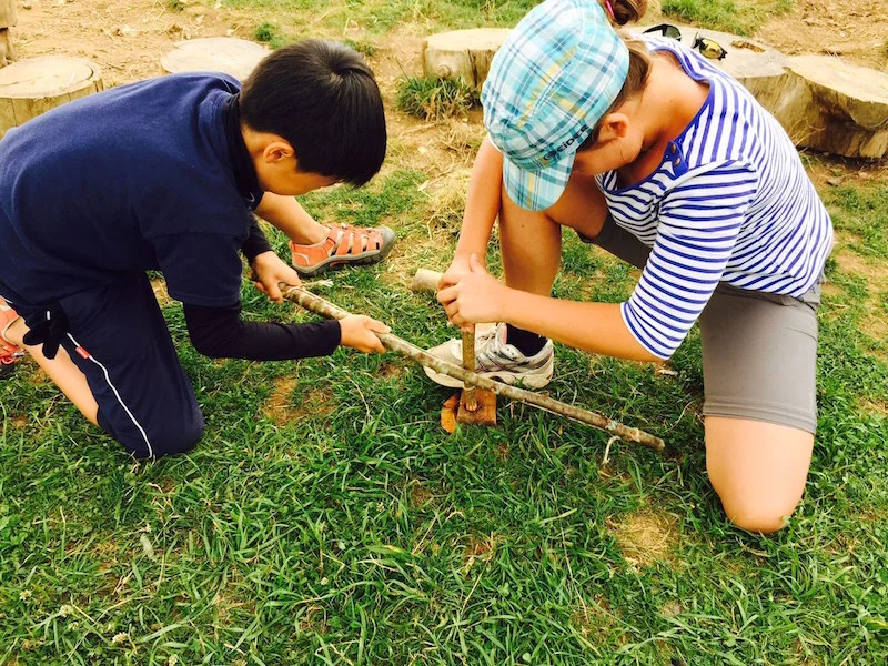 attempting fire by friction using a bow drill