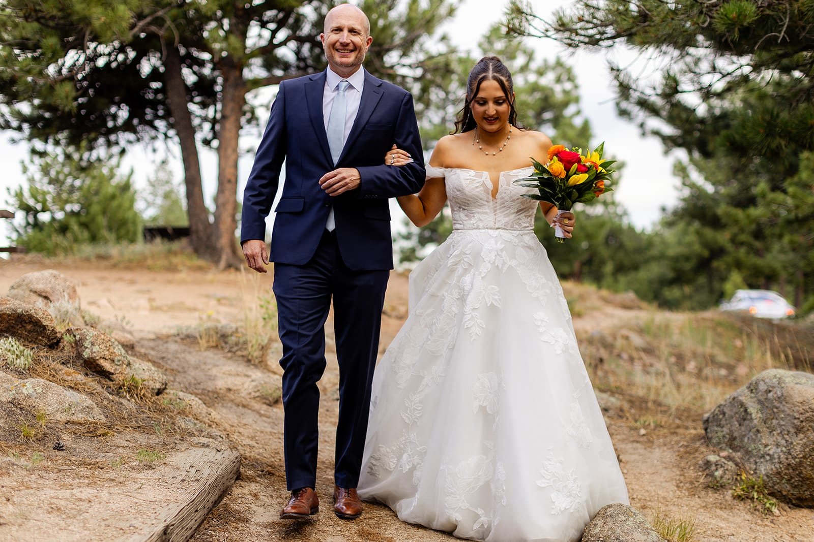 An eloping bride walks the trail with her father as a mini processional.