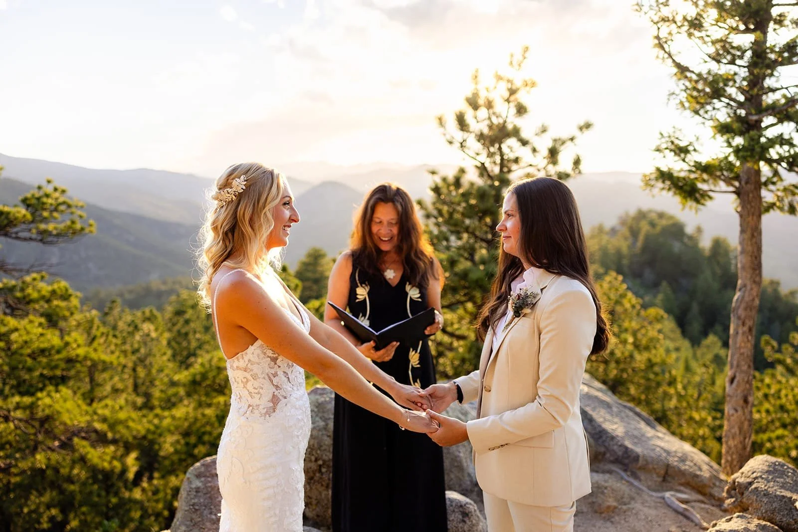 Officiant Lisa leading a couple holding hands during a sunset ceremony with a beautiful view.