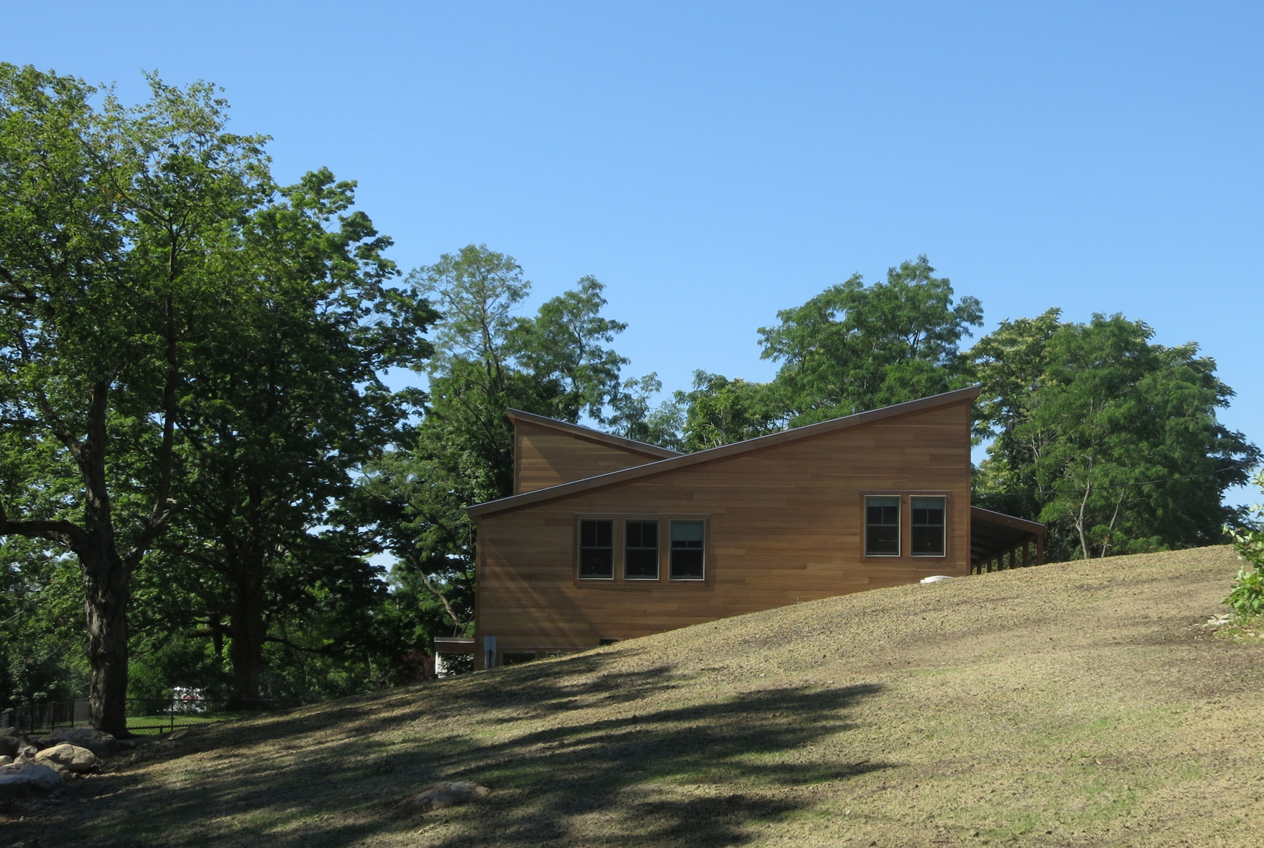 Nestled into the topography and designed to take advantage of the hillside slope, the building features direct at-grade access to an expansive outdoor environment from both the first and second floors.