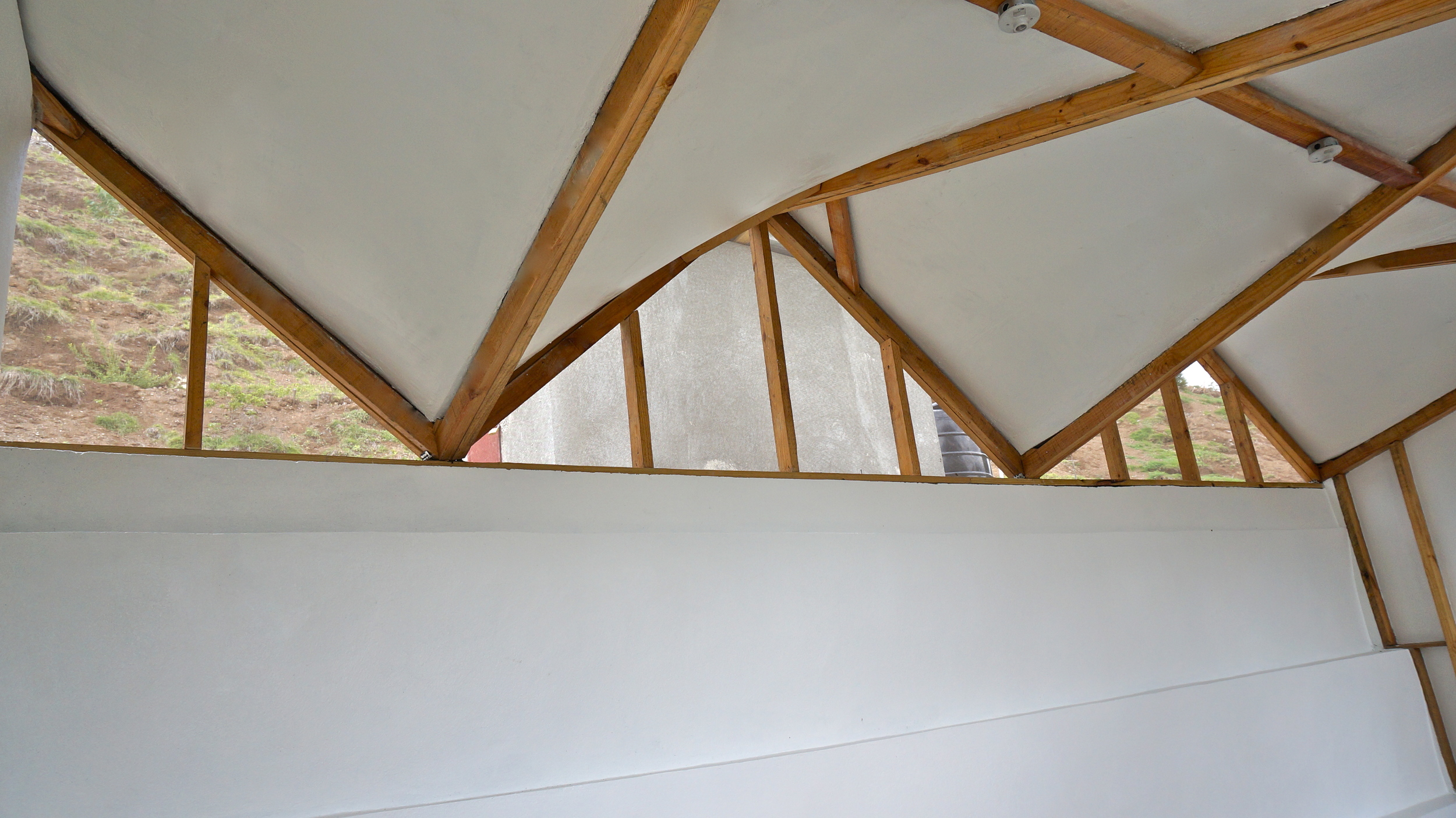  Inside medical room, white walls and ceiling improve lighting and add sense of cleanliness. &nbsp;The undulating form of the hyper-parabolic roof is exposed to create areas for light and air to come inside.&nbsp;&nbsp; 