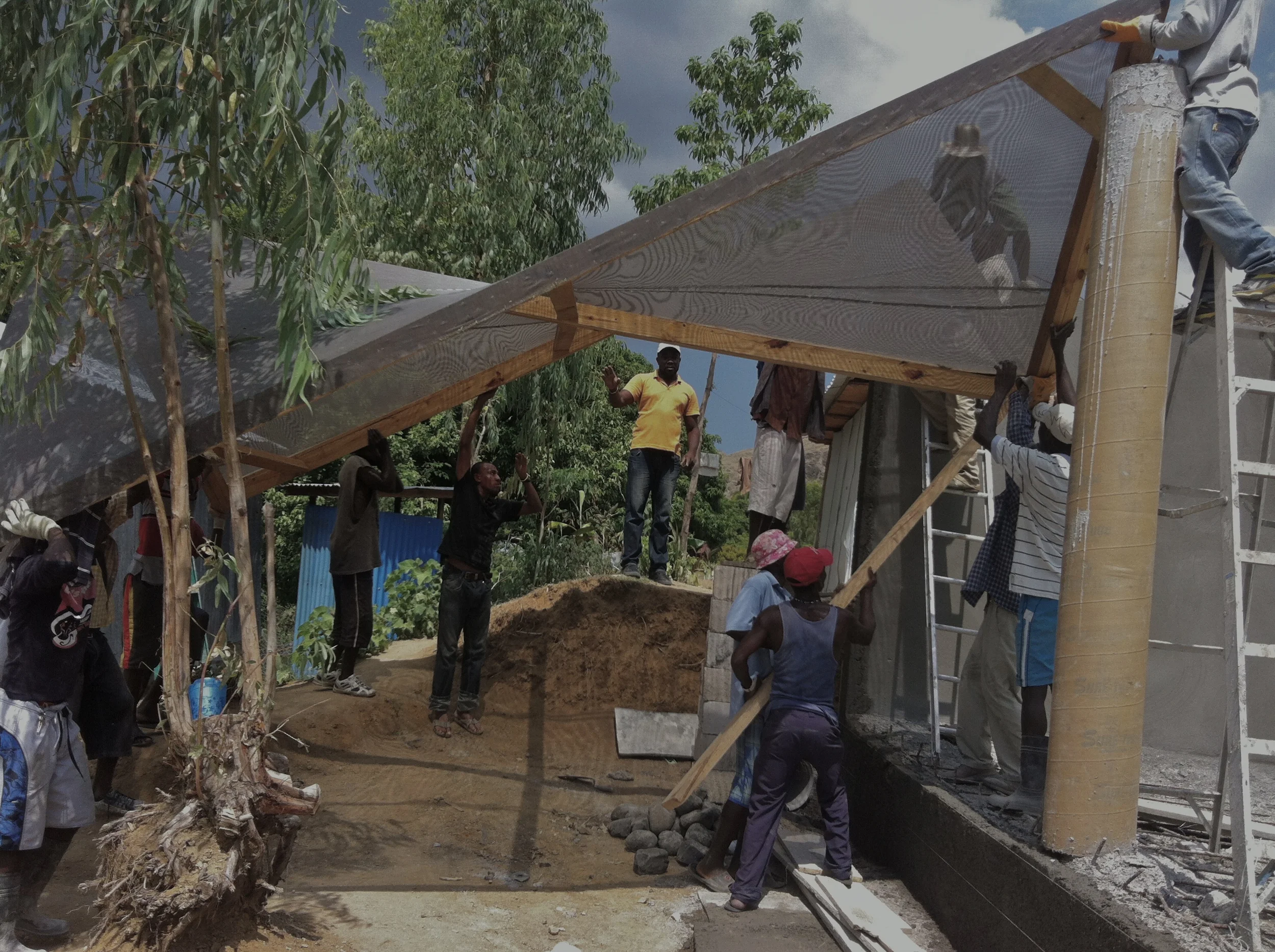  the light weight hyper-parabolic roof section is hand lifted onto the reinforced concrete posts&nbsp;before the painted on acrylic cement mixture is applied.&nbsp; 