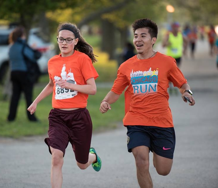 Christian running with a Running Mates student at the 4-Mile Classic race on May 18, 2017