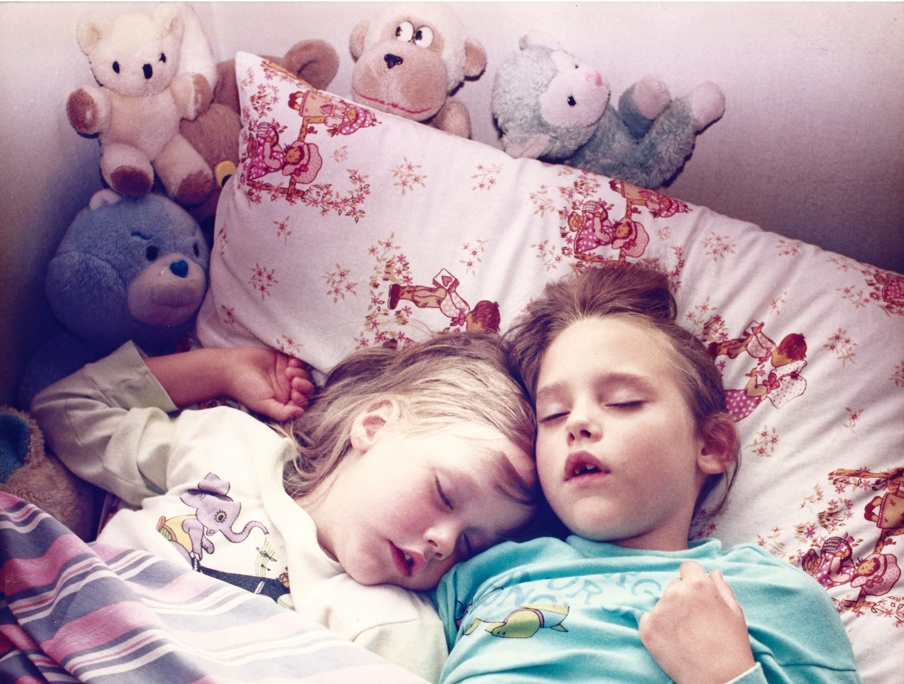 Julianna Skariynska in bed with her sister, Asia at her childhood home in Warsaw Poland during late 1980's.