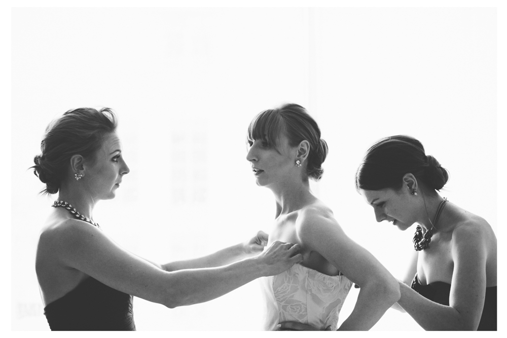 Sisters helping bride into her Viktor and Rolf wedding dress at Four Seasons Toronto.