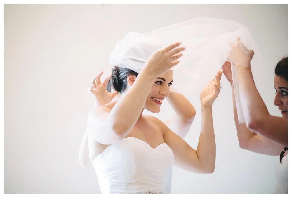 Bride getting help from bridesmaids at The Briars on her wedding day.