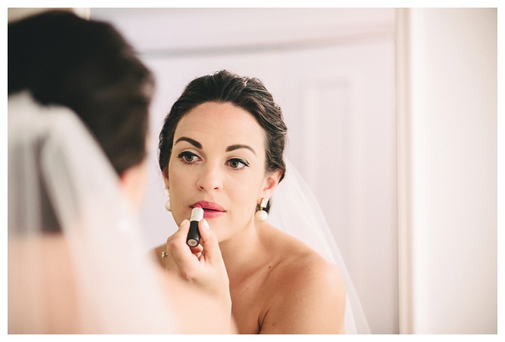 Bride applying lipstick at The Briars.