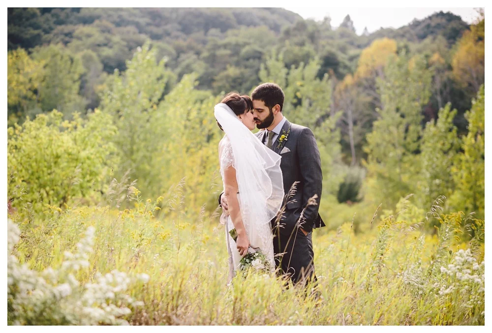 couple kiss in the grass at Brickworks Toronto