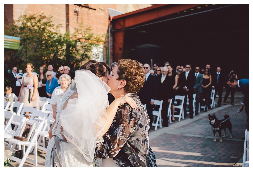Bride kissing mom during a wedding ceremony at Brickworks, Toronto.