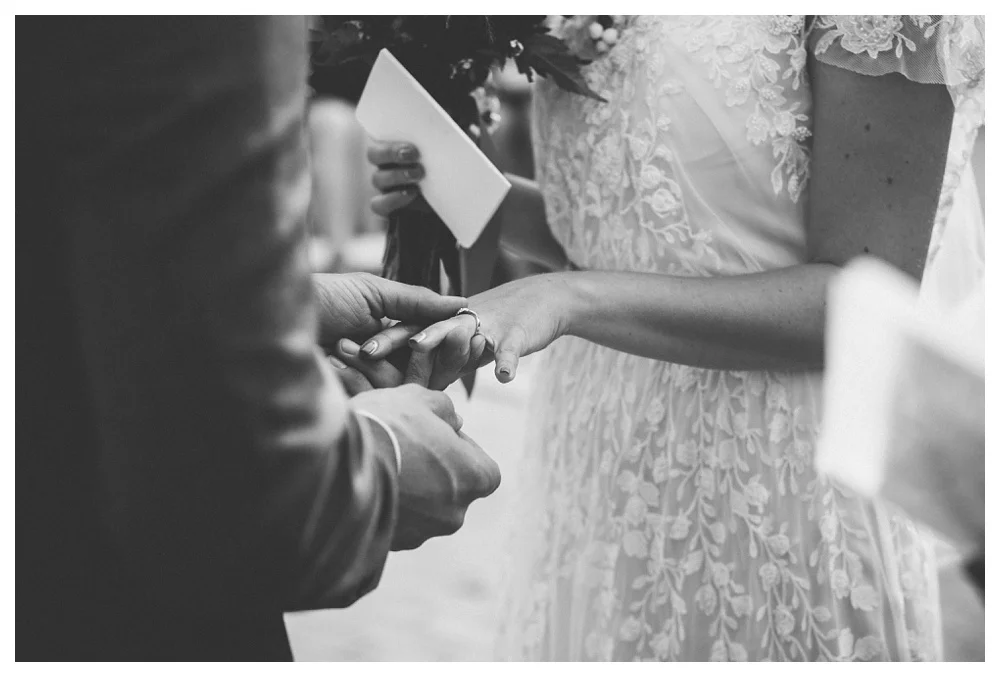Groom putting on a ring during wedding ceremony at Brickworks, Toronto.