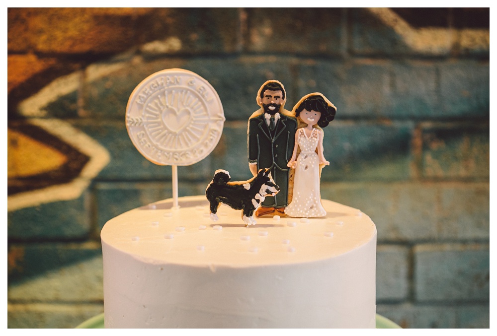 Bride and groom cookie cake topper with a dog.