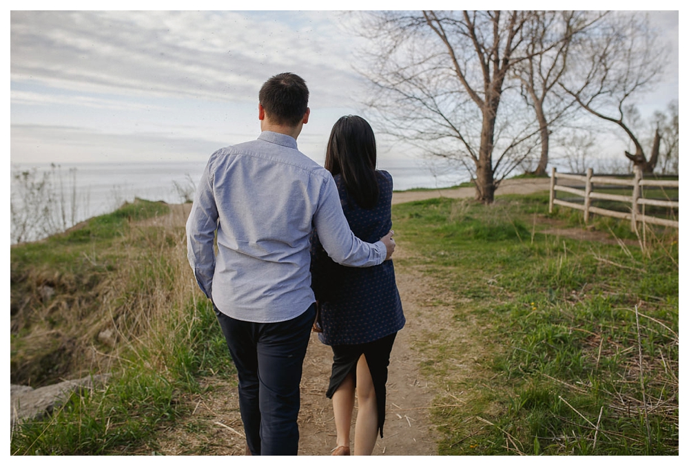 The groom gently embraces his bride finding the spot for their engagement photos at Scarborough Bluffs. 