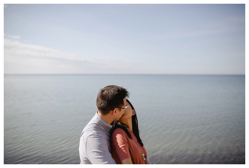 Their love expressed by a kiss in their beach time engagement photo shoot. 