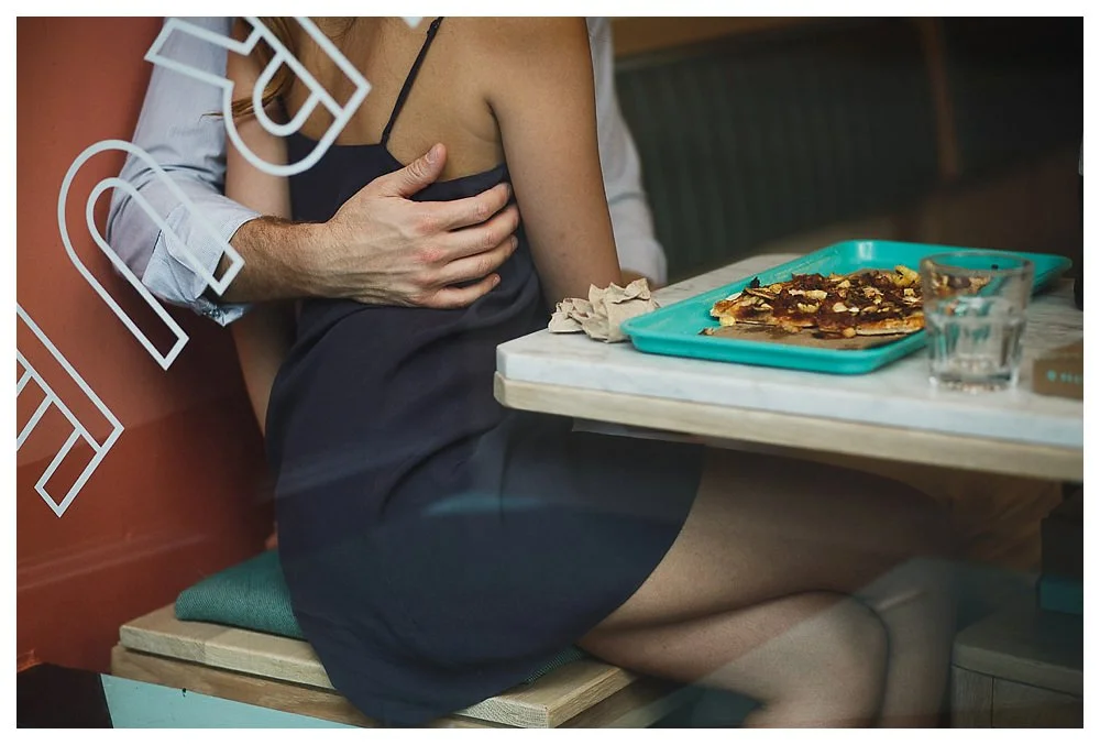 The groom's embrace of his bride on their engagement day makes the pizza taste sweeter. 