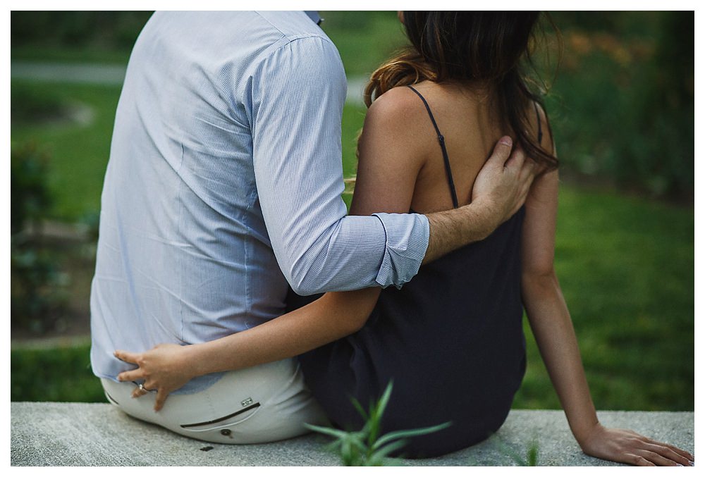 The gentle hold of his hand on her back speaks of love at their engagement photo shoot. 