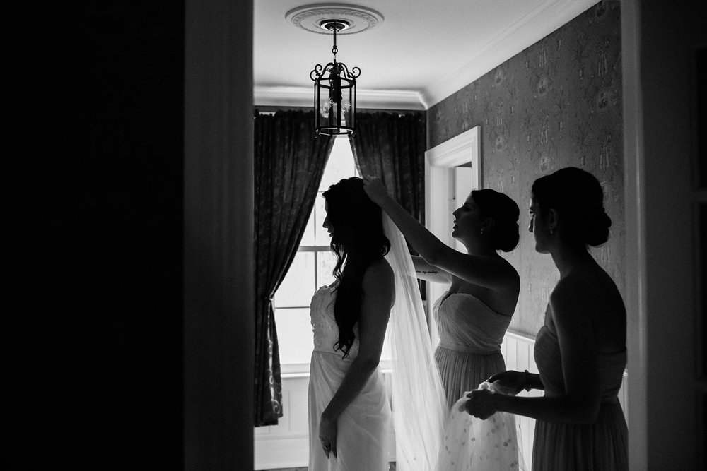 Bridesmaids putting veil on bride for Kurtz Orchards wedding.