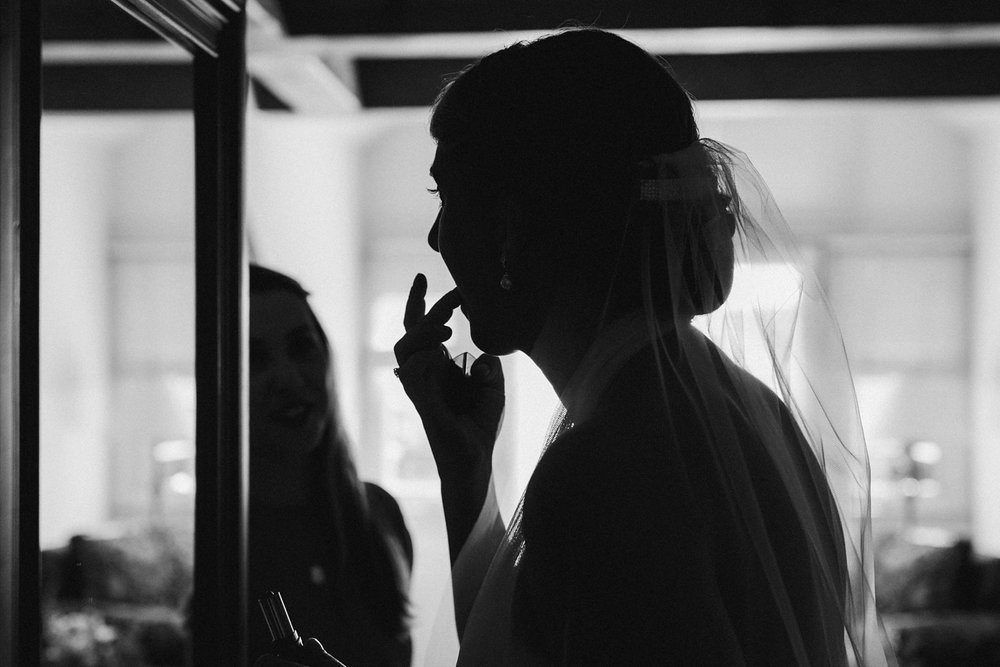 Bride putting make up for wedding in Vermont.