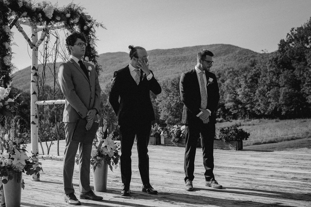 Groom wipes tears at Vermont wedding.