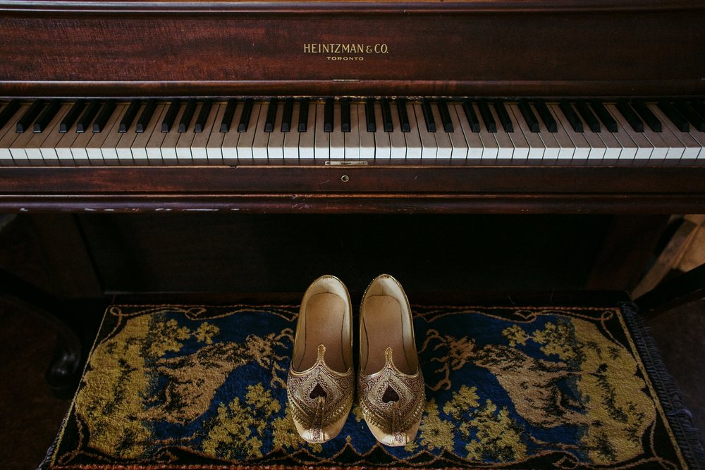 Indian groom shoes on piano bench in Toronto.