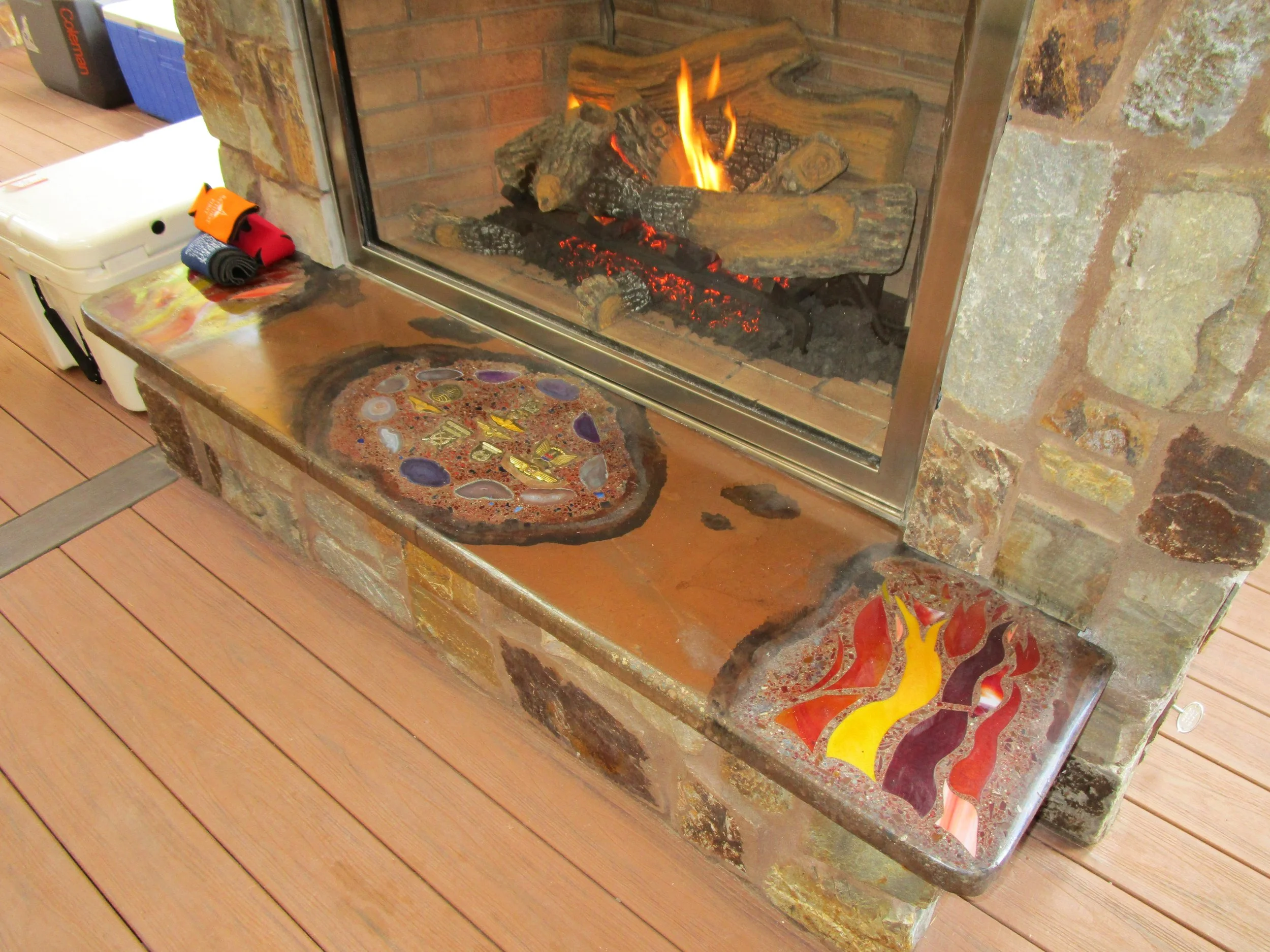Homeowner is a glass artist and made a custom concrete hearth with colorful decorative glass features.