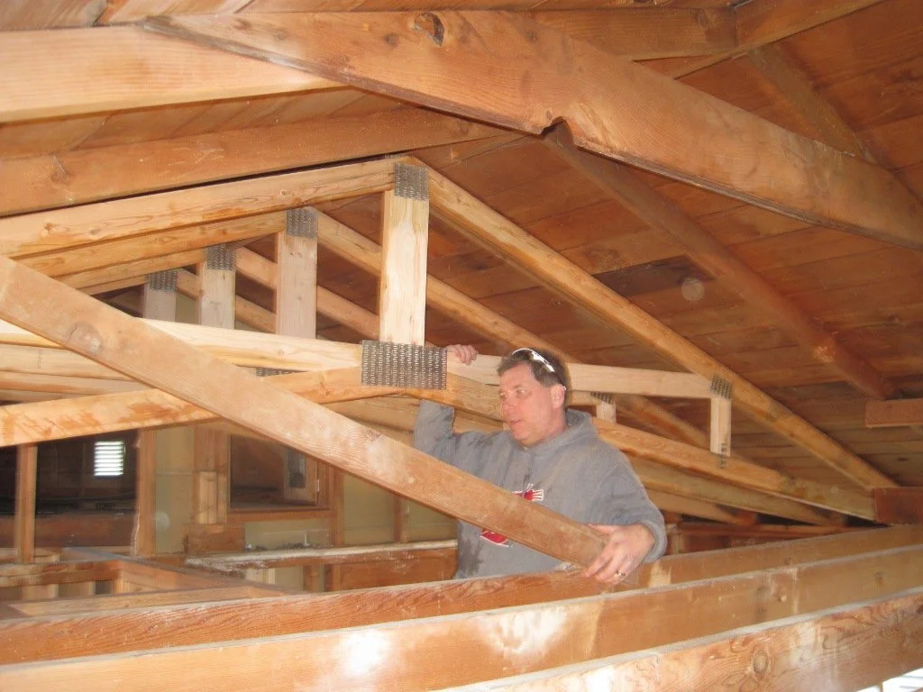 One by one the scissor trusses are set, and the old roof framing cut out incrementally.