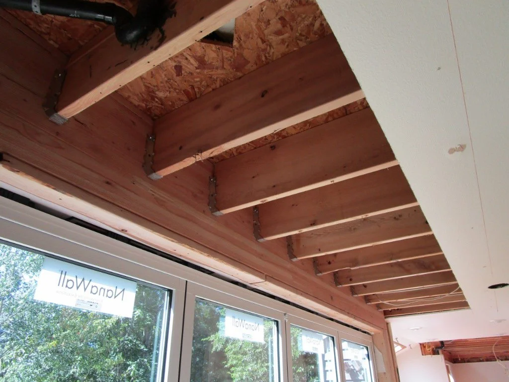 Existing floor joists are hung from the new glu lam beam.