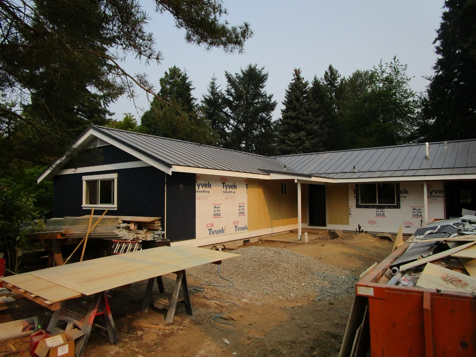 Metal roof on, siding started.