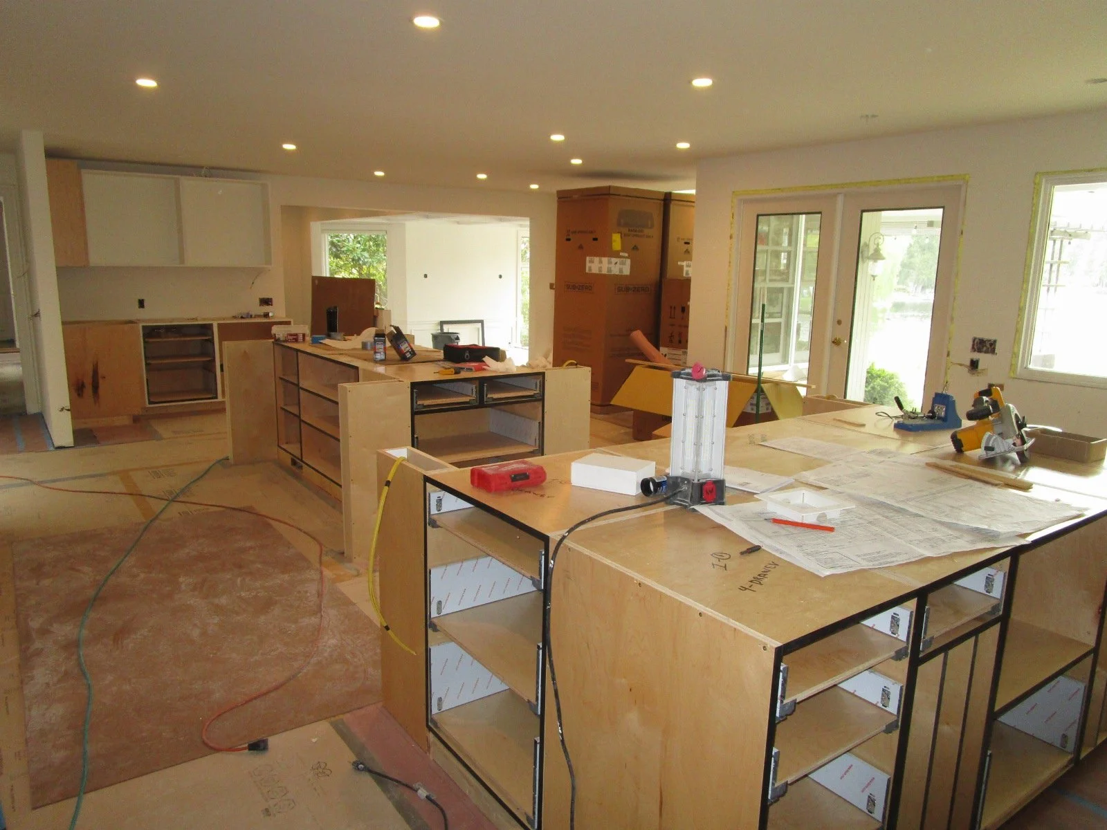 Cabinets are starting to load in. View from the new kitchen across the three old rooms, now one long room.