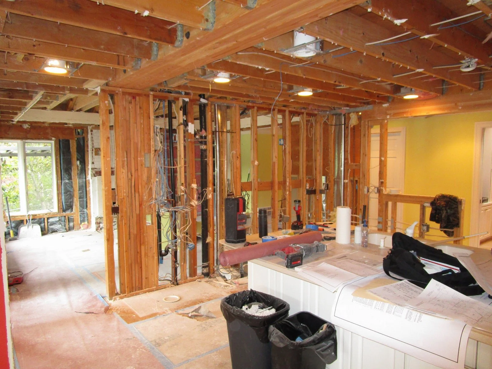 Same shot, demo has started. This wall will come out. The big challenge is rerouting all of the plumbing and heating pipes and ducts. Note the HUGE triple glu-lam in the ceiling, from a prior major re